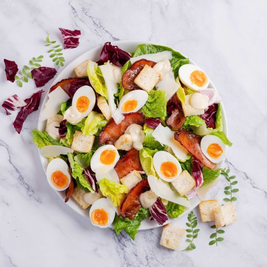 Caesar salad with maple bacon, shaved parmesan, soft boiled egg, sourdough croutons