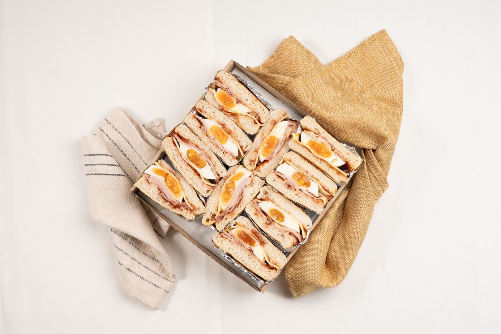Shared Classic English Muffin Box Filled With Fried Egg, Bacon, Cheese And Tomato Relish