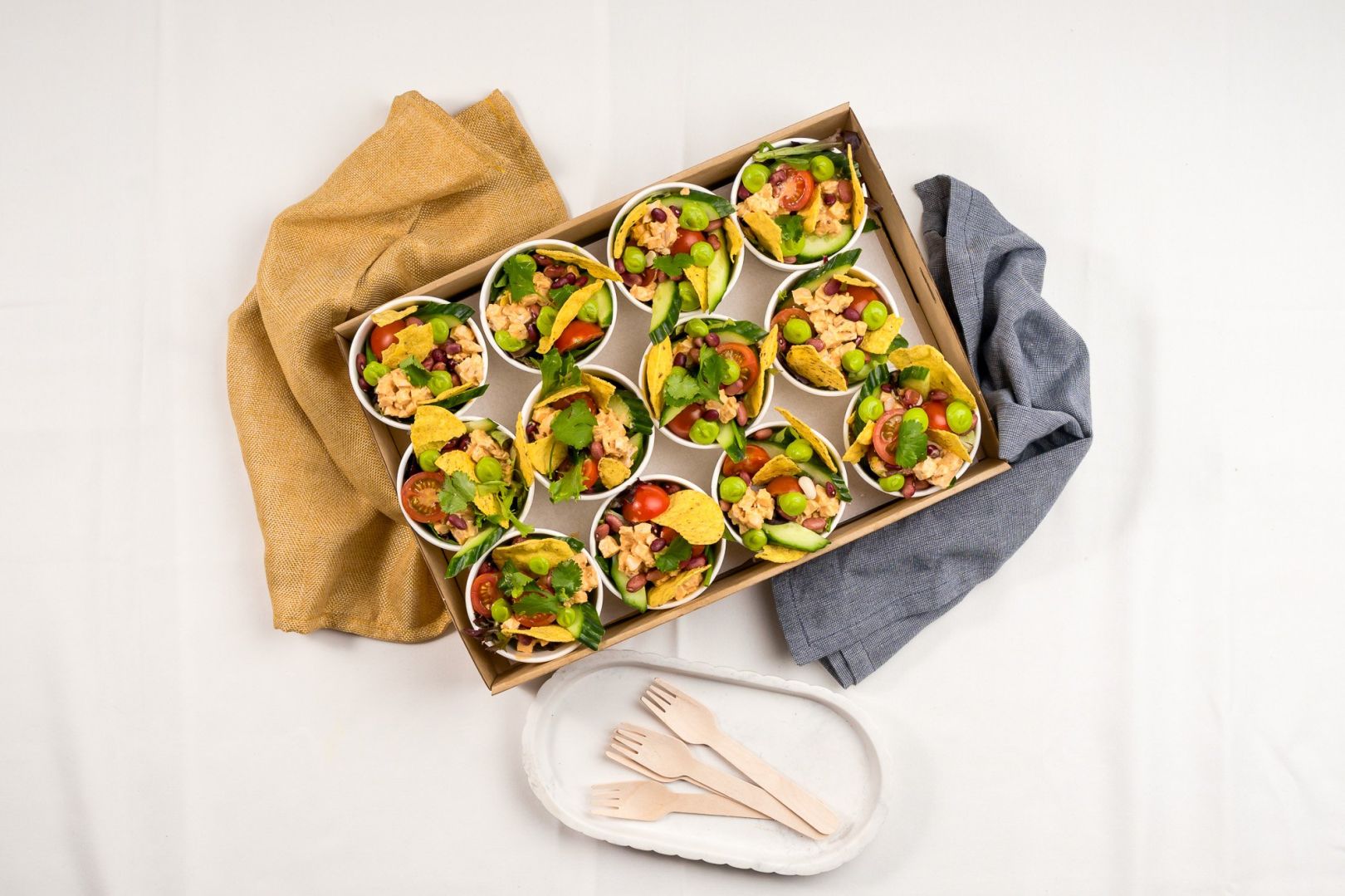 Baja Naked Burrito Salad Mini Cup, Chipotle chicken, BBQ Corn ribs, Mixed Salad Leaves, Smashed Tostadas, Avo puree, Cherry Tomatoes, Cucumber, Red Onion, Fresh Coriander, Toasted Seeds, Seeded Mustard &  Apple Cider Vinegar Dressing