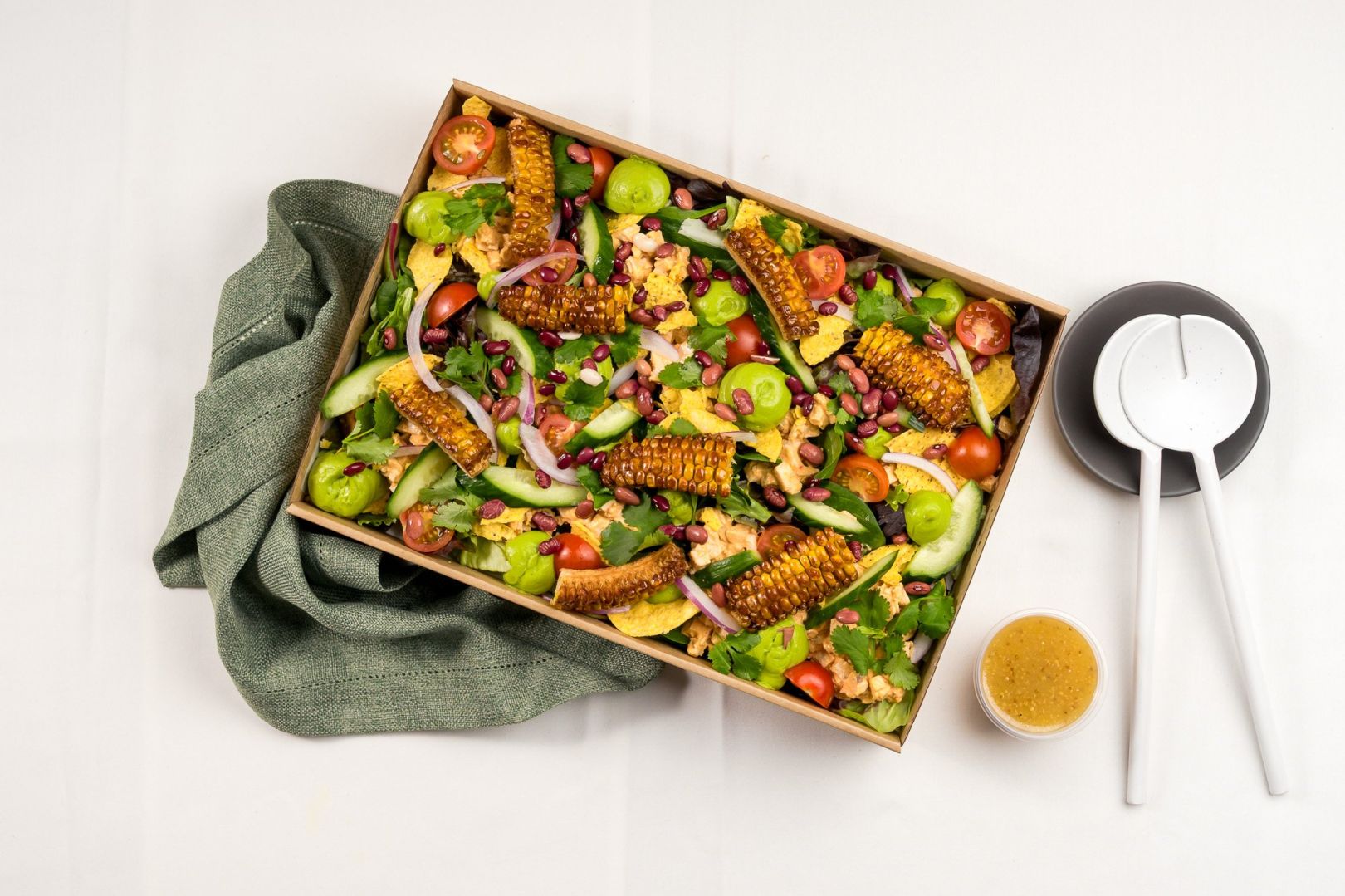Baja Naked Burrito Salad, Chipotle chicken, BBQ Corn ribs, Mixed Salad Leaves, Smashed Tostadas, Avo puree, Cherry Tomatoes, Cucumber, Red Onion, Fresh Coriander, Toasted Seeds, Seeded Mustard &  Apple Cider Vinegar Dressing