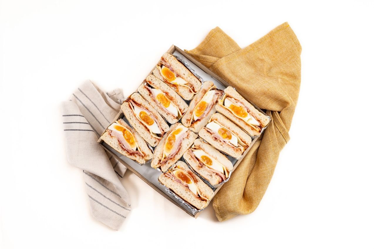 Shared Classic English Muffin Box Filled With Fried Egg, Bacon, Cheese And Tomato Relish