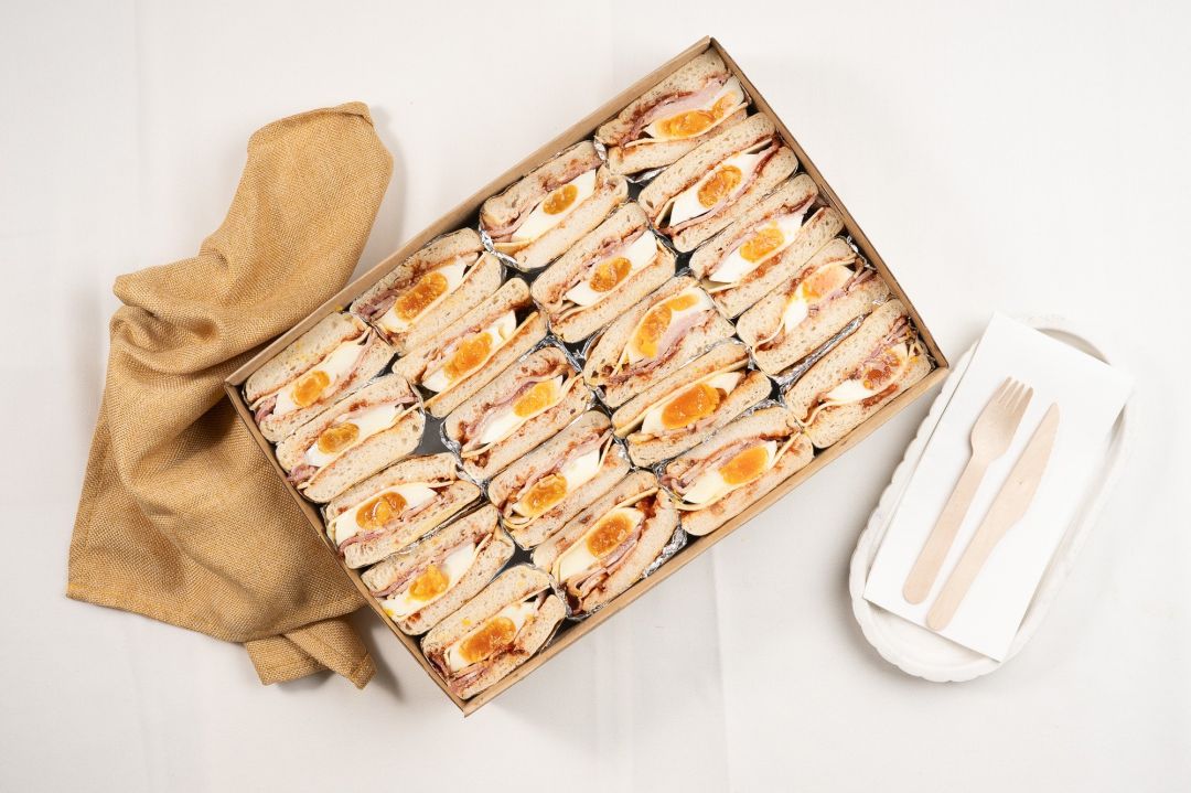 Shared Classic English Muffin Box Filled With Fried Egg, Bacon, Cheese And Tomato Relish
