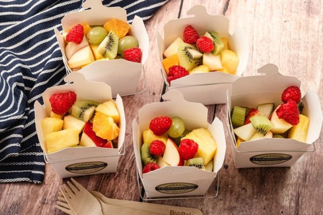 FRESH FRUIT SALAD served in a noodle box with wooden fork 