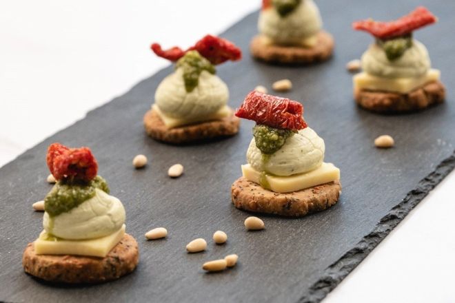 PARMESAN SHORTBREAD canape topped with cheddar cheese slice, whipped basil pesto cream cheese & sunblush tomato (V)