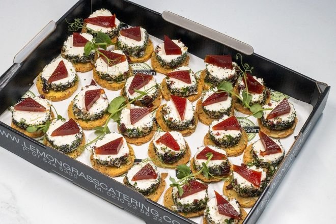 CHRISTMAS CHEESE LOG TOPPED WITH FRUIT PASTE ON SAVOURY PARMESAN CRACKER - Canape Platter - 20 (V) Housemade Christmas cheese log rolled in chopped walnuts and Christmas herbs. 