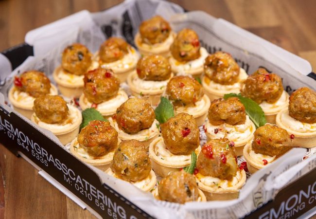 THAI PORK BALL CANAPE glazed with sticky sweet chilli sauce served on a mango cream tart. Served warm. 