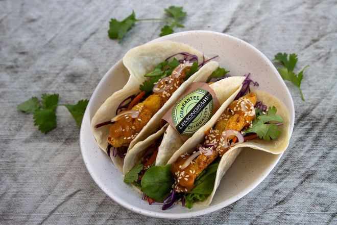 CHICKEN TACO - Crumbed chicken fillet with fresh salad greens, grated cheese, shredded cabbage, carrot, honey mustard mayo sauce & toasted seeds in a soft taco 