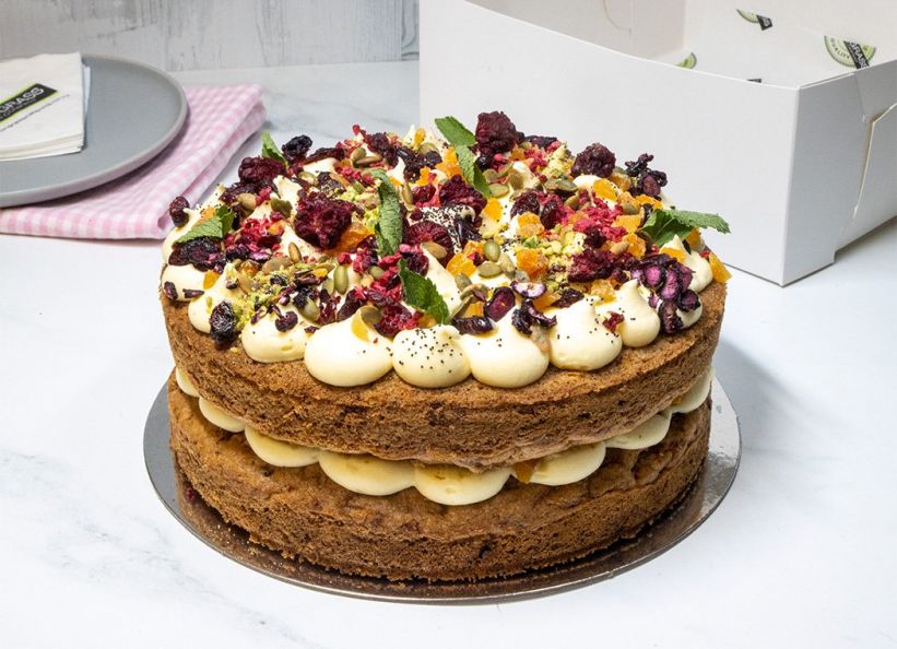 CARROT & WALNUT CAKE  - 23cm round - double cake layer filled & topped with with citrus cream cheese frosting and decorated with dried apricots, cranberries, pistachios, seeds & toasted walnuts. Presented in a cake box 