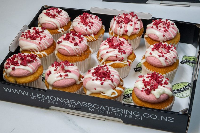 VANILLA BEAN & RASPBERRY CUPCAKE BOX (12) - Vanilla cupcakes topped with raspberry buttercream decorated with freeze dried raspberries in a cupcake box with lid 