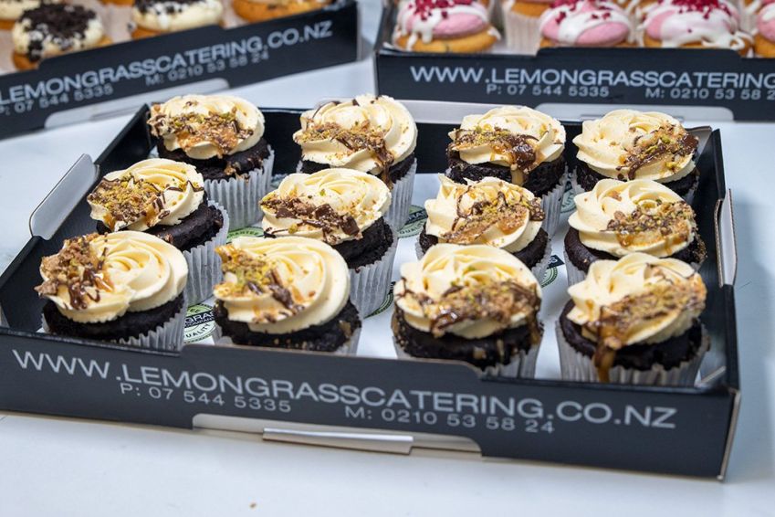 CHOCOLATE AND SALTED CARAMEL CUPCAKES - Chocolate cupcake with salted caramel filling and topped with salted caramel buttercream icing - presented on a black biodegradable platter 