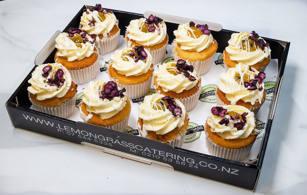 BLUEBERRY AND PASSIONFRUIT CUPCAKE - Vanilla bean cupcake filled with blueberry compote topped with passionfruit buttercream and passionfruit compote - presented on a black biodegradable platter 