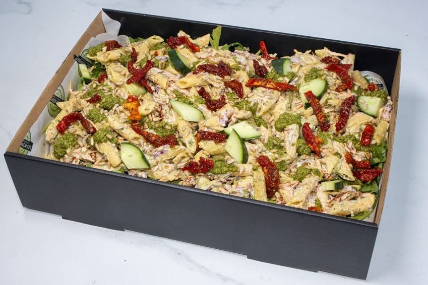 PESTO AND SUNBLUSH TOMATO PENNE PASTA SALAD BOX - with creamy basil pesto mayonnaise dressing, sunblush tomatoes, sliced red onion, fresh salad greens, shredded red cabbage & carrots (V) Sunday Catering 