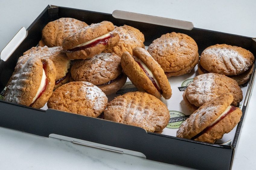 MONTE CRISTO COOKIES - Crisp coconut cookies sandwiched together with raspberry jam and vanilla bean buttercream