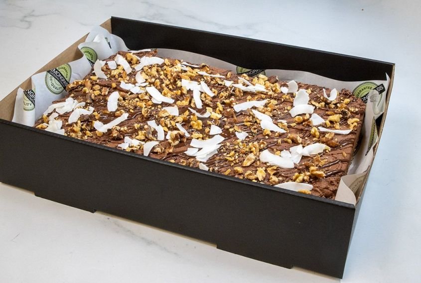 BANANA CAKE SLAB - 25 x 30 cm - Classic banana cake topped with a rich chocolate icing, chopped nuts & coconut shards. Served whole