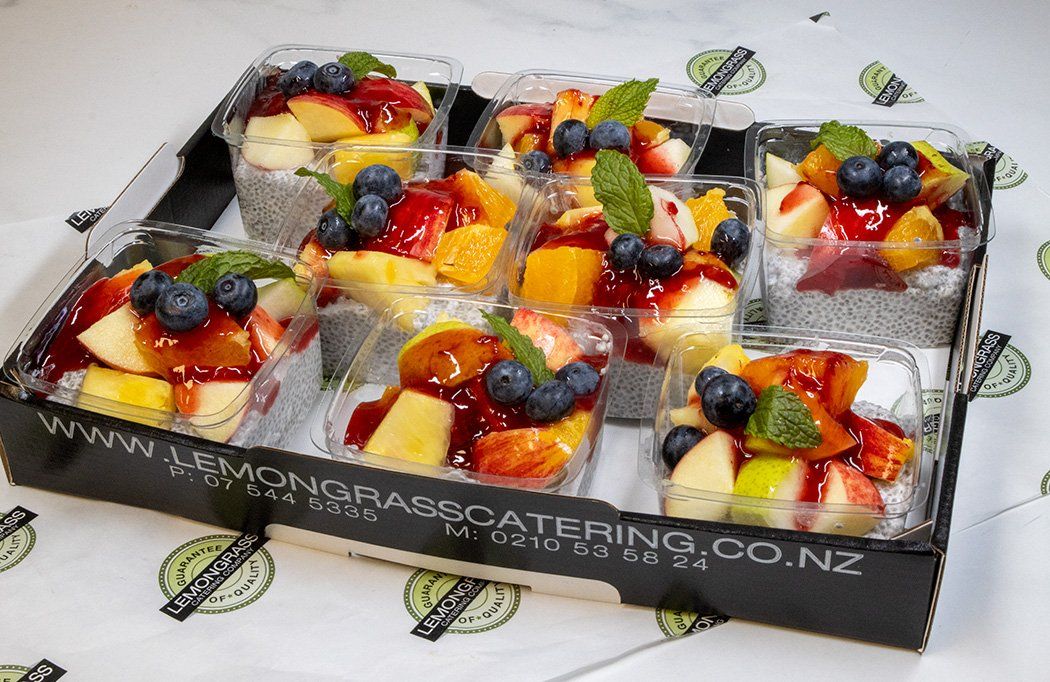 CHIA SEED PUDDING with creamy coconut cream, maple syrup, fruit compote, crushed pistachios (GF,DF,VEGAN) served with wooden spoon