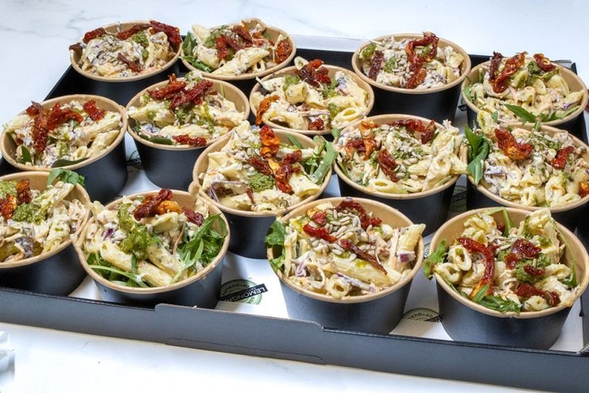 PESTO AND SUNBLUSH TOMATO PENNE PASTA SALAD INDIVIDUAL TUBS with creamy basil pesto dressing, sunblush tomatoes & fresh salad greens (V) - wooden forks included - Sunday Catering 