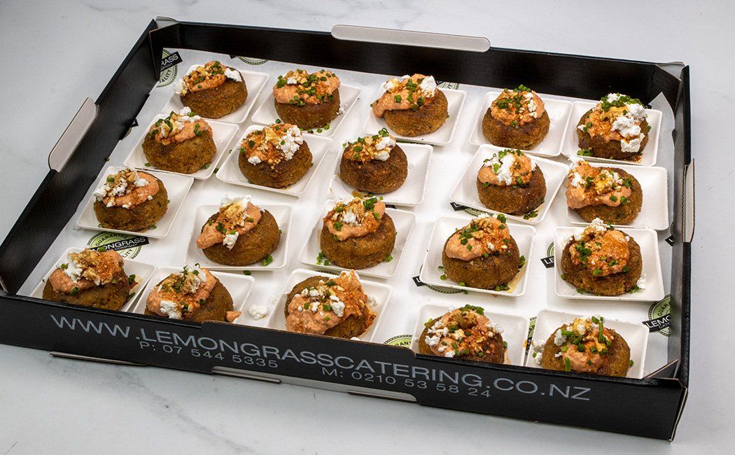 MIDDLE EASTERN BAKED FALAFEL BITES with our house made Mahummara sauce topped with crushed feta served on individual tasting spoons (GF, Vegetarian) Served warm