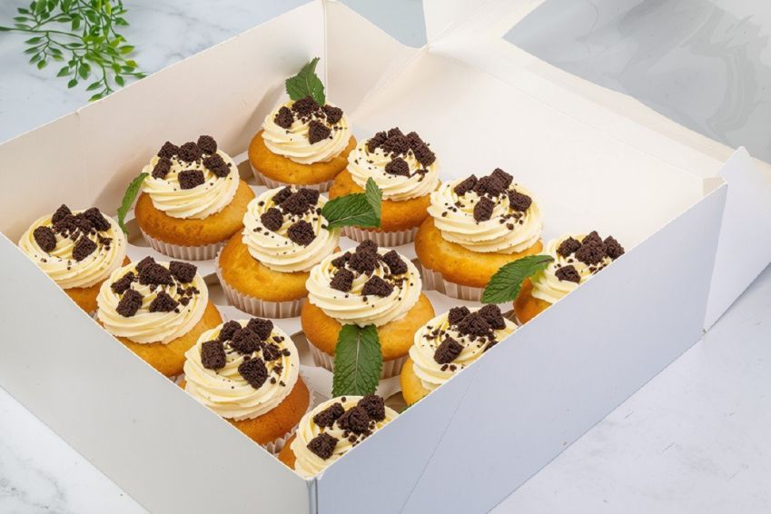 COOKIES AND CREAM CUPCAKE BOX (12) -  Vanilla bean cupcake filled with a rich chocolate centre topped with vanilla buttercream frosting & coated in crushed oreo biscuits - presented in a cupcake box with lid 