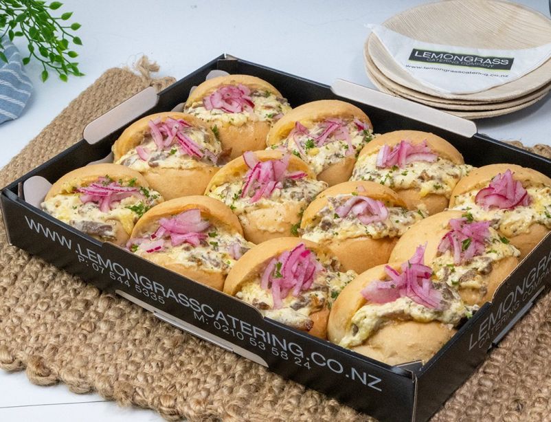 PHILLY-STYLE SHREDDED BEEF SLIDER MELT with rich cream cheese, cheddar, caramelized onions in soft slider roll topped with pickled red onions & heated in oven - Served HOT