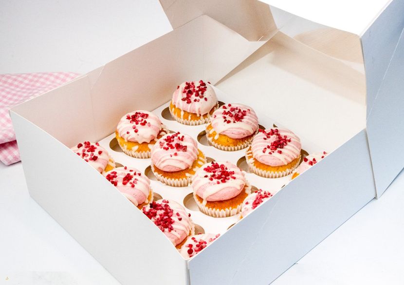 VANILLA BEAN AND RASPBERRY CUPCAKE BOX (12) - Vanilla cupcakes topped with raspberry buttercream decorated with freeze dried raspberries in a cupcake box with lid 