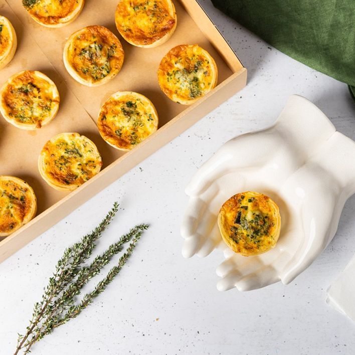Box of assorted flavoured homemade quiches, seasoned with herbs