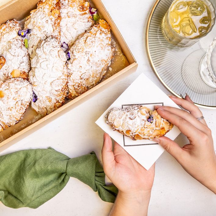 Box of almond croissants, topped with powdered sugar