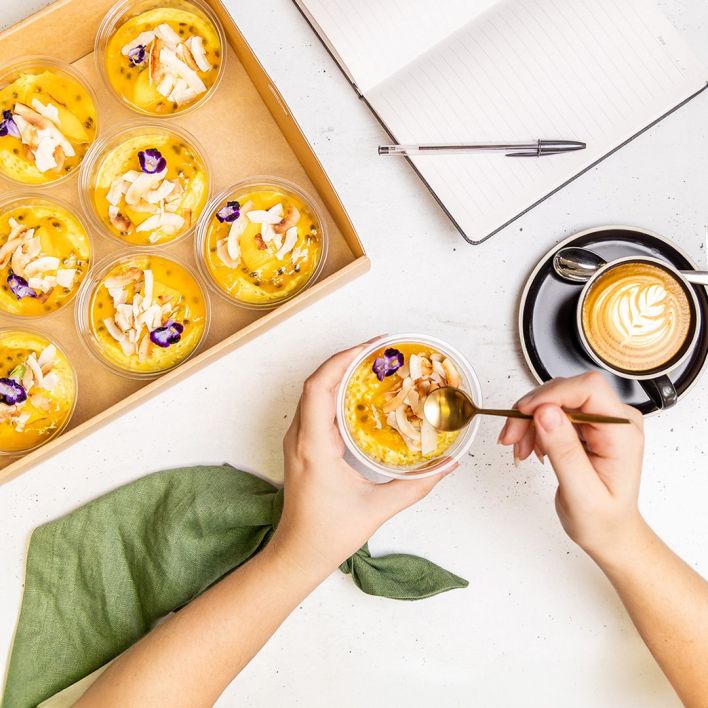 Box of individual tropical puddings with coconut shavings & passionfruit