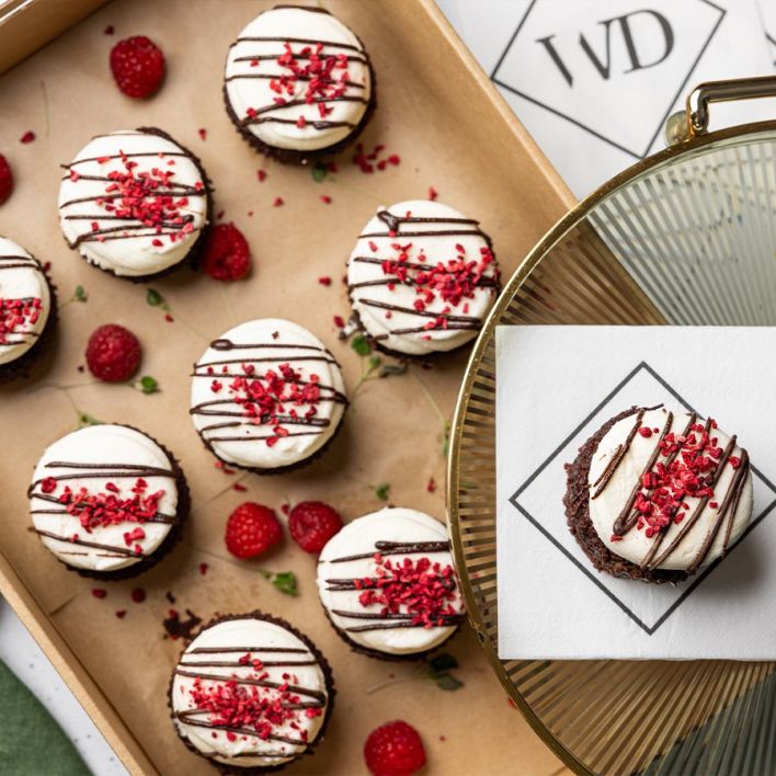 Box of vegan chocolate cupcakes with raspberry topping